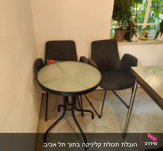 שולחן עגול ושני כיסאות בפינת חדר